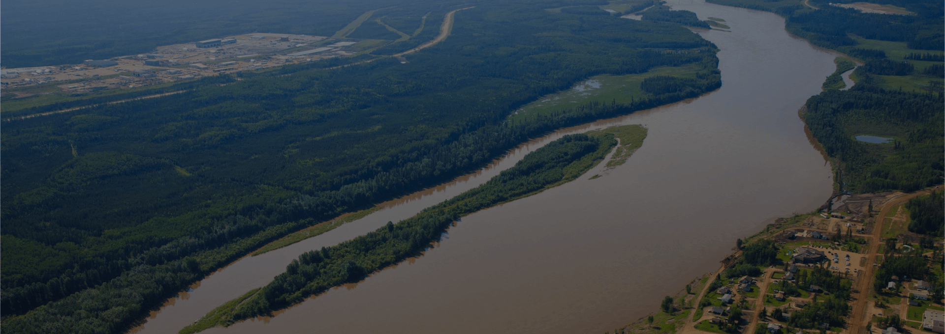 Aerial view of Fort McKay beside the river, with forest on both banks